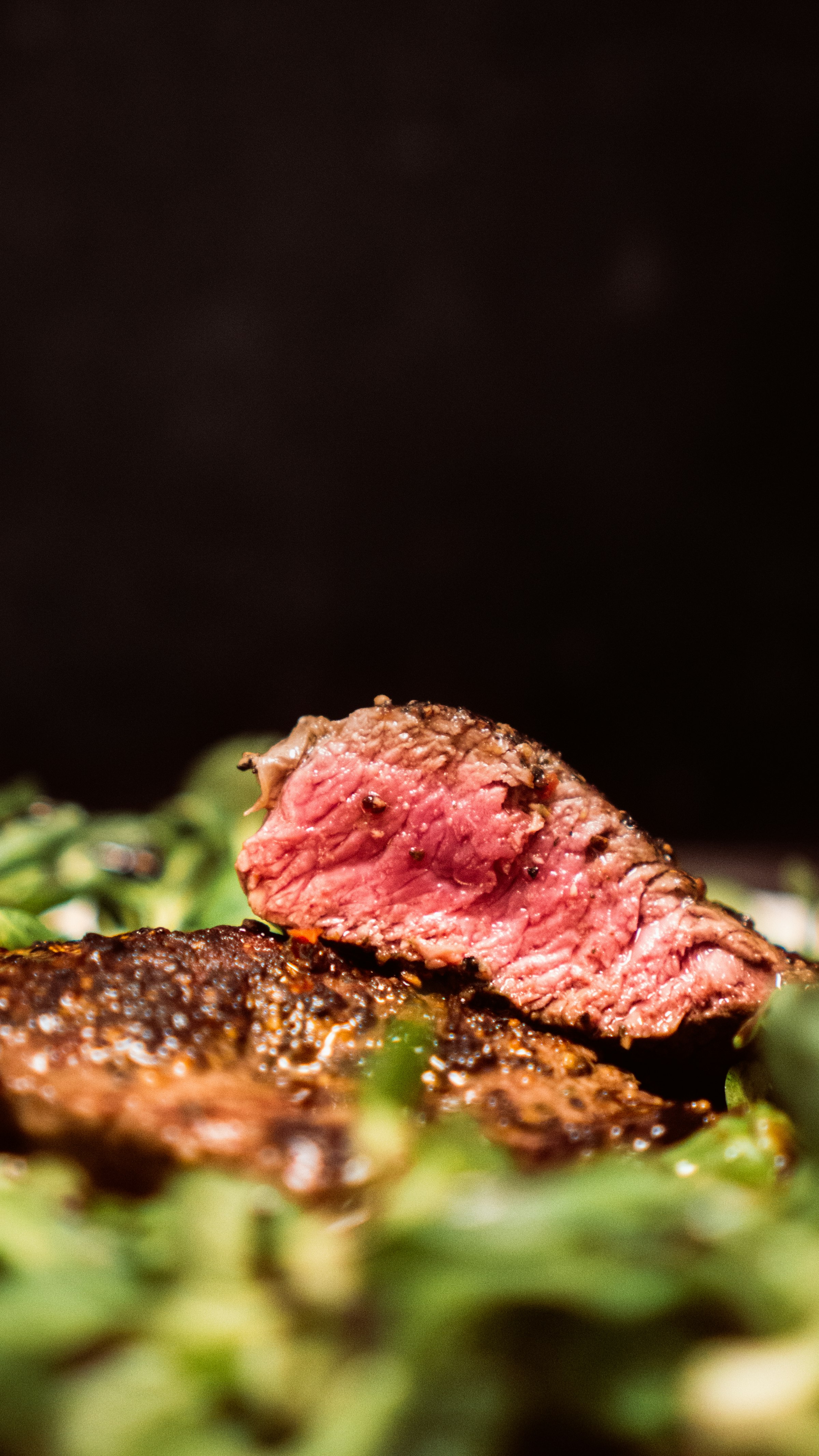Sliced dry-aged tomahawk steak, deep pink inside with a charred crust
